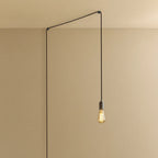 Plug-in pendant with a filament bulb, graphite, lit, hung from a ceiling corner