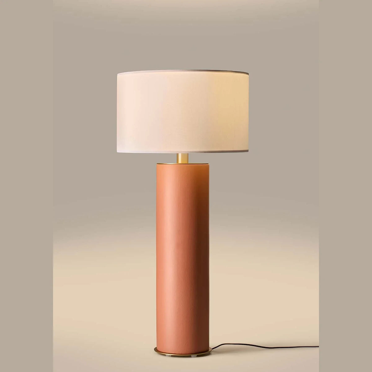 Extra-tall hand-painted ceramic cylinder table lamp, in a pink terracotta colour, lit, with a shade (sold separately)