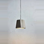 Faceted concrete pendant, single shade lit against a pale wall