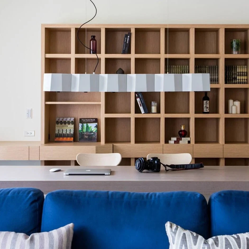 Faceted metal linear pendant, in white above a sofa