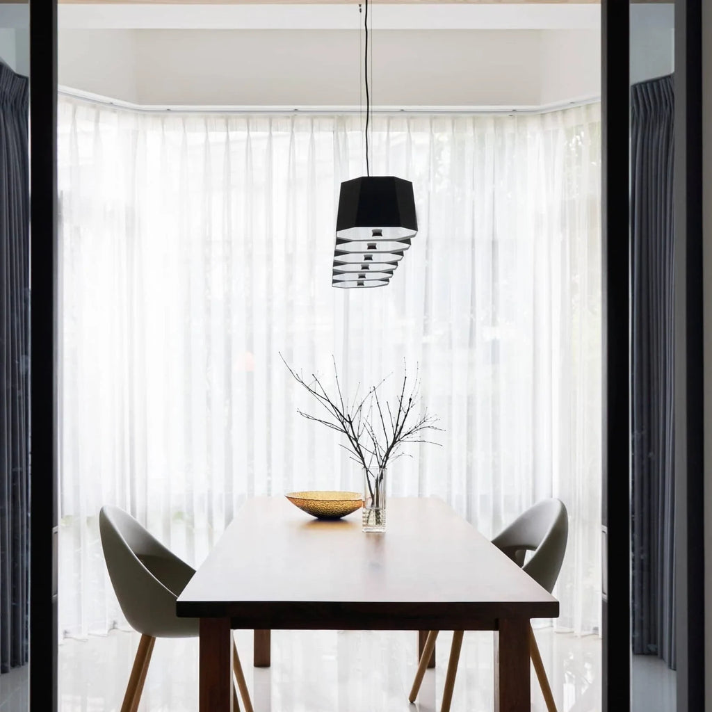 Faceted metal linear pendant, end-on view above a dining table