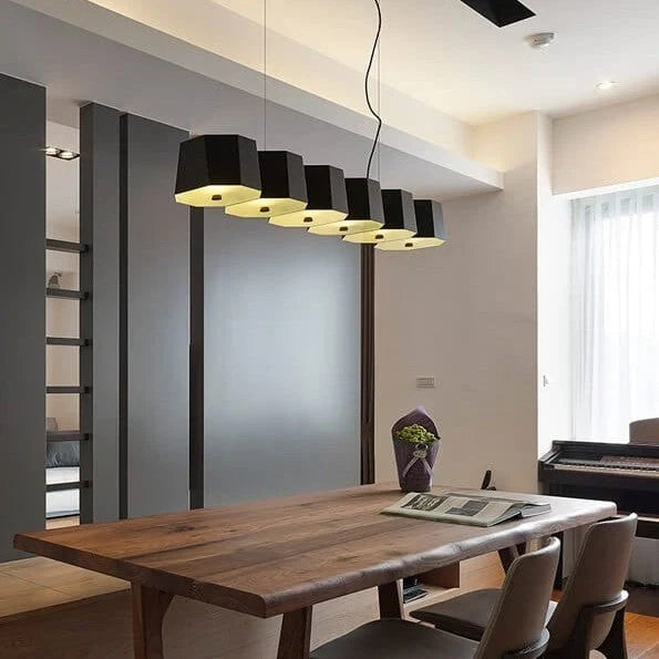 Faceted metal linear pendant, above a long dining table