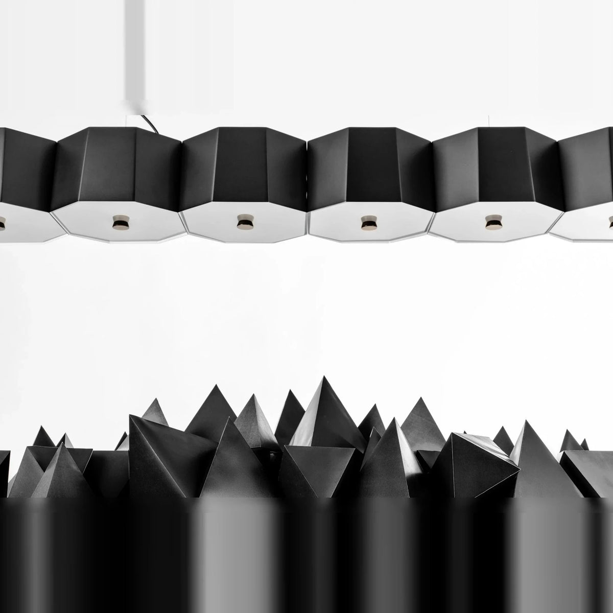 Faceted metal linear pendant, close-up of the black shades