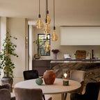 Five-drop cluster pendant, graphite, with decorative bulbs (not included) above a dining table