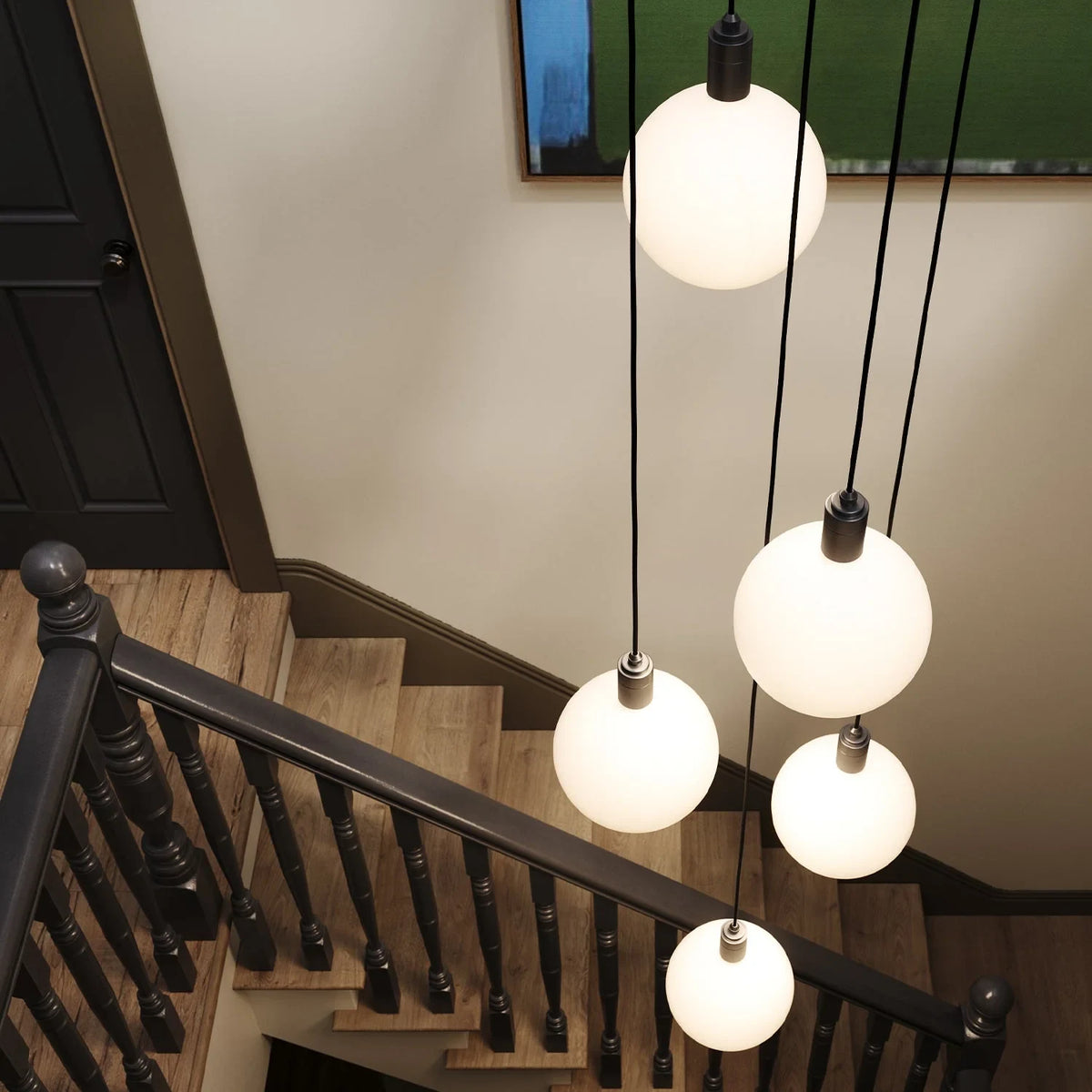 Five-drop cluster pendant with opal globe bulbs, brass, above a staircase