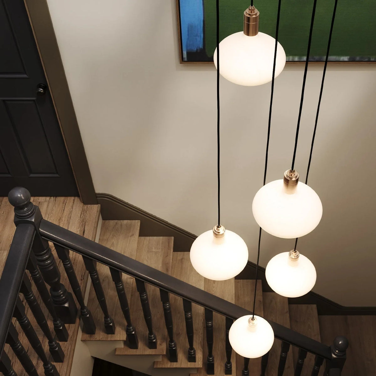 Five-drop cluster pendant with opal oval bulbs, brass, above a staircase