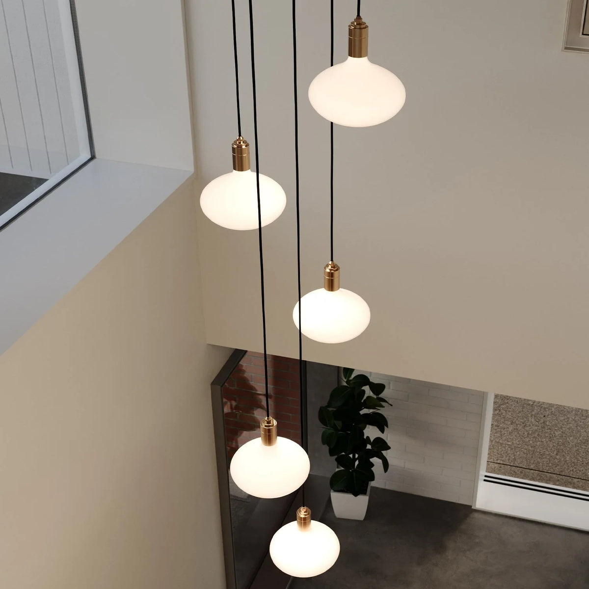 Five-drop cluster pendant with opal oval bulbs, brass, seen from a landing