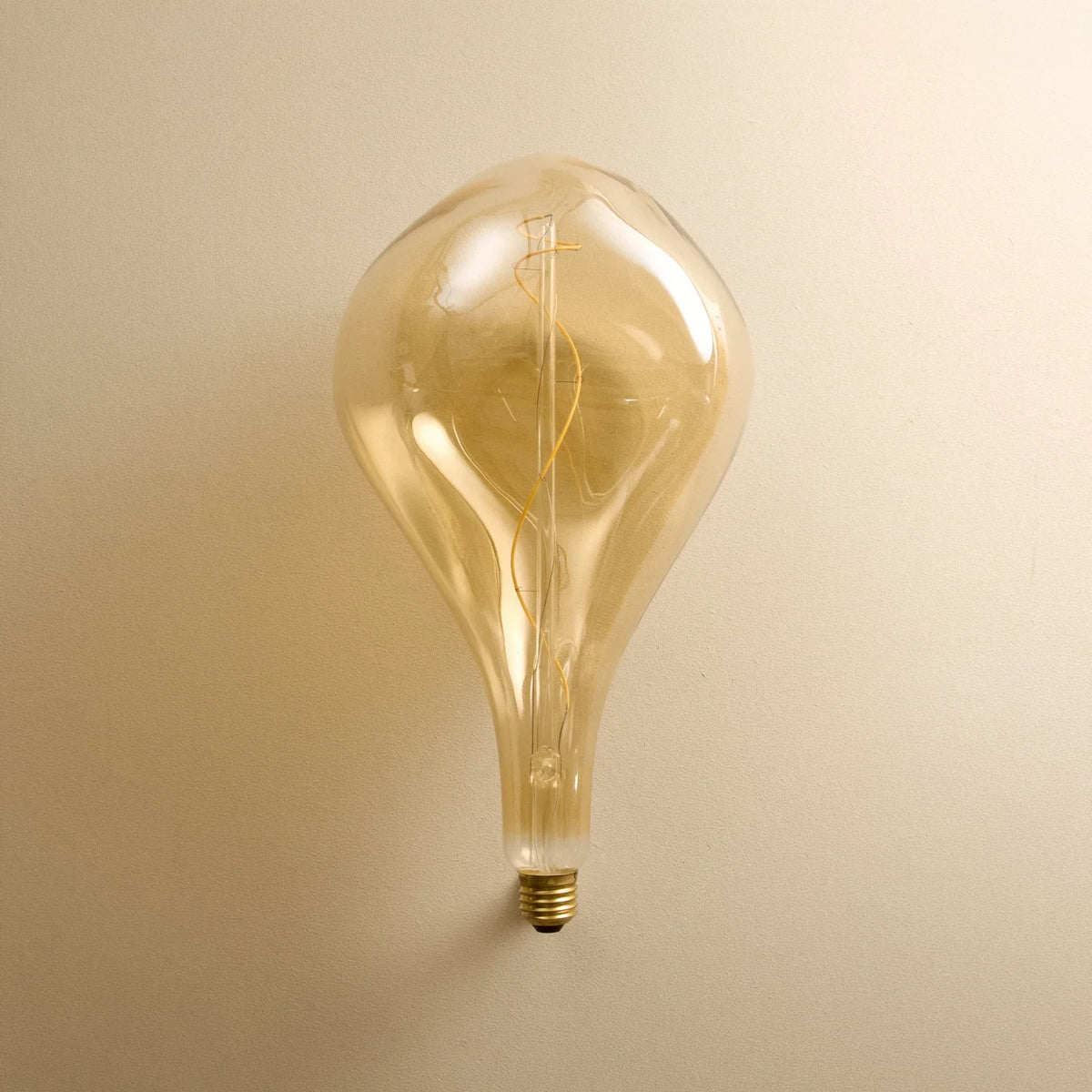 Five-drop cluster pendant with tinted sculptural bulbs, graphite, close-up of a lit tinted bulb