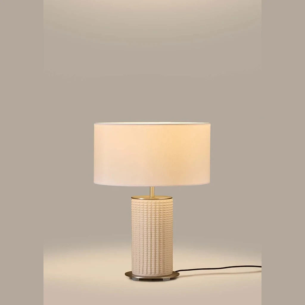 Fluted ceramic table lamp, in cream, lit, with a pale linen shade (not included)