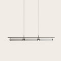 Fluted glass tube linear LED pendant, on a plain background