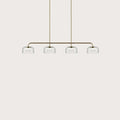 Four-dome linear glass pendant with integrated LED, gold bar with four clear shades on a plain background