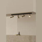 Four-spot ceiling bar light, with gold spots, in a room with a stone counter