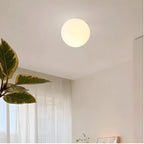 Frosted glass globe wall light, lit near a window