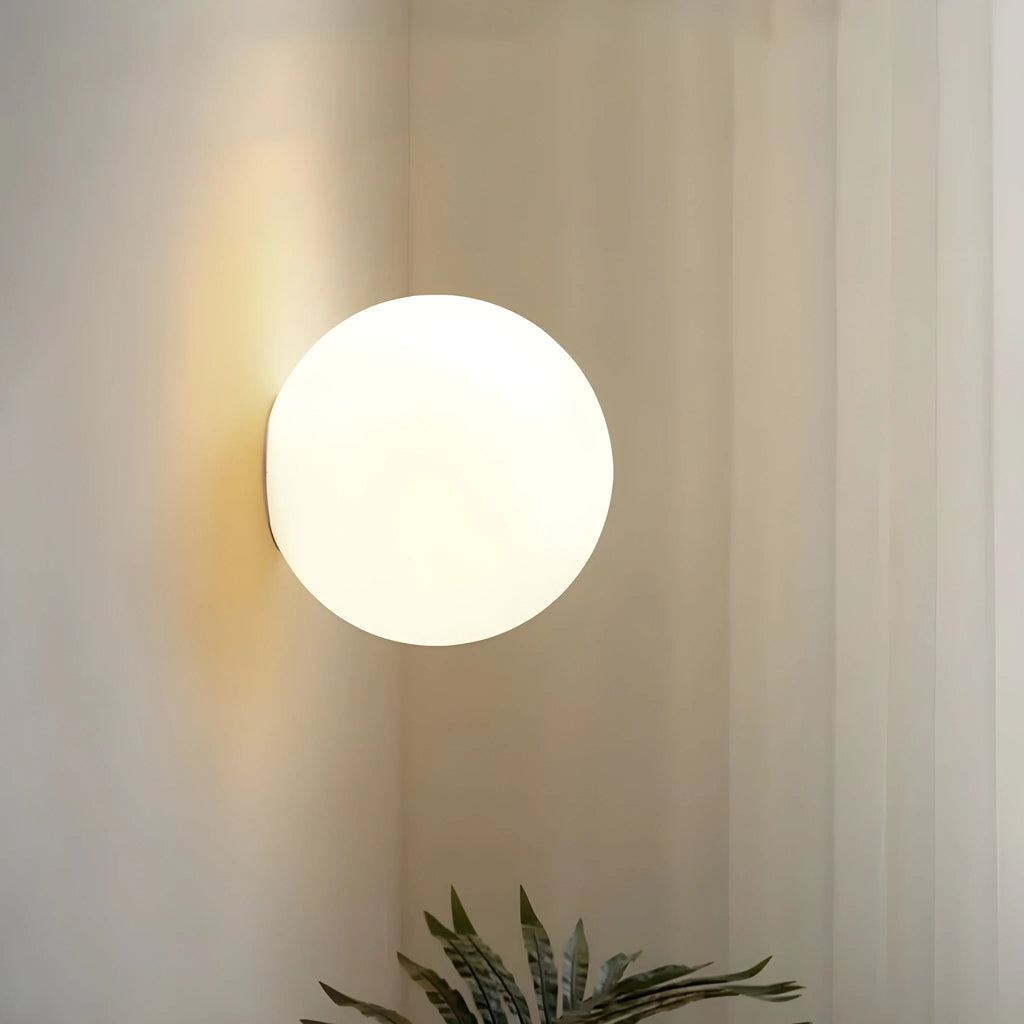 Frosted glass globe wall light, lit, close-up