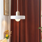 Glass pendant light with ring shade, white, by a red curtain