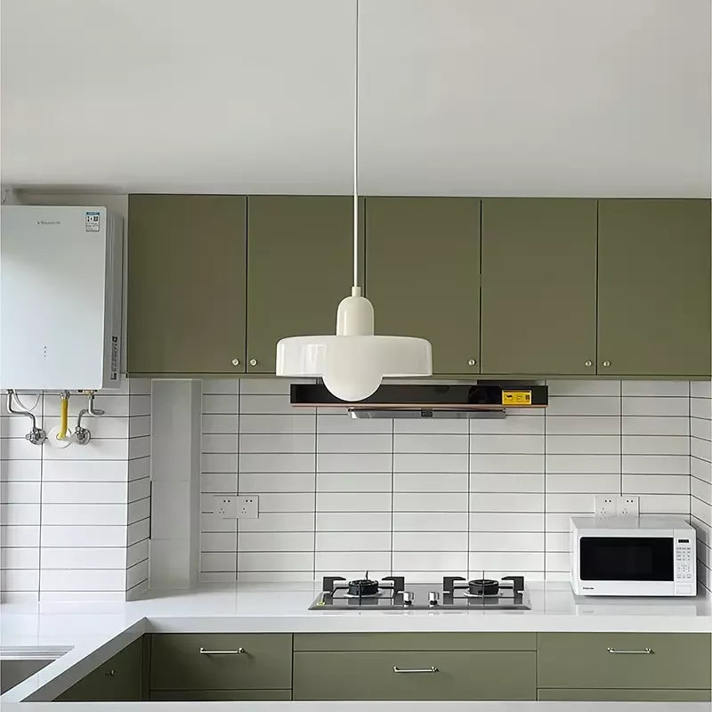 Glass pendant light with ring shade, white, above a kitchen