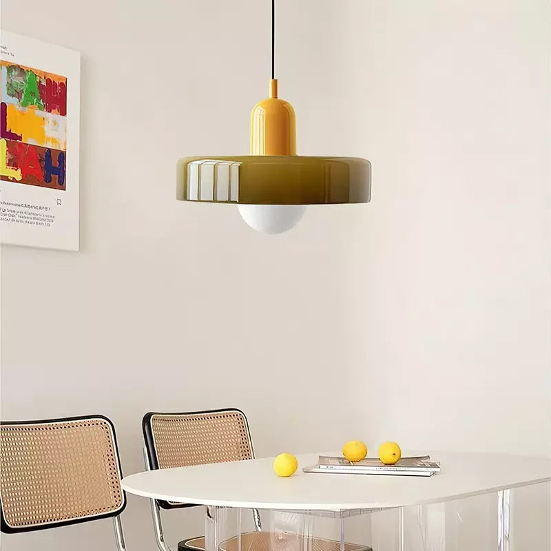 Glass pendant light with ring shade, yellow, above a dining table