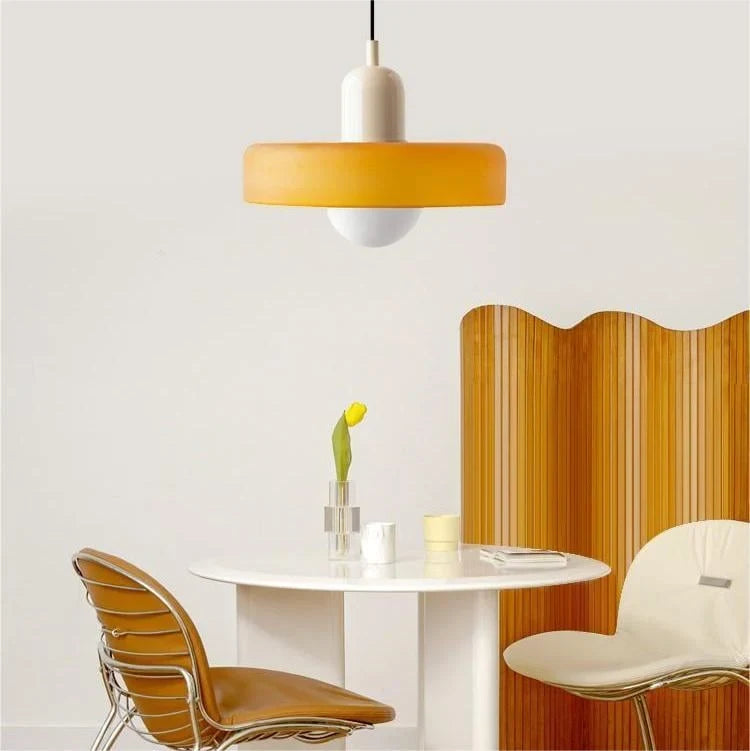 Glass pendant light with ring shade, yellow, above a round table