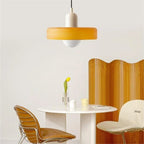 Glass pendant light with ring shade, yellow, above a round table