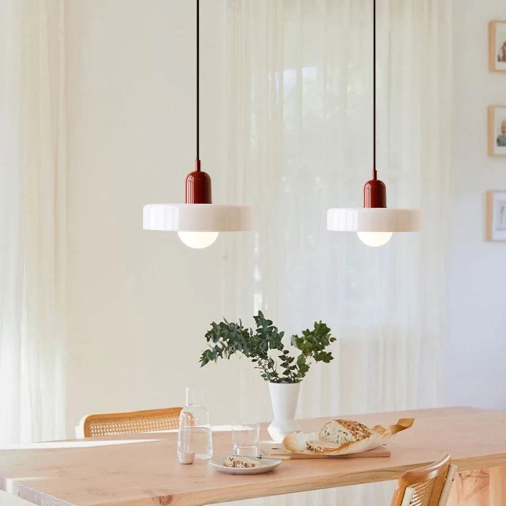 Glass pendant light with ring shade, white pair above a table