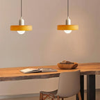 Glass pendant light with ring shade, yellow pair above a table