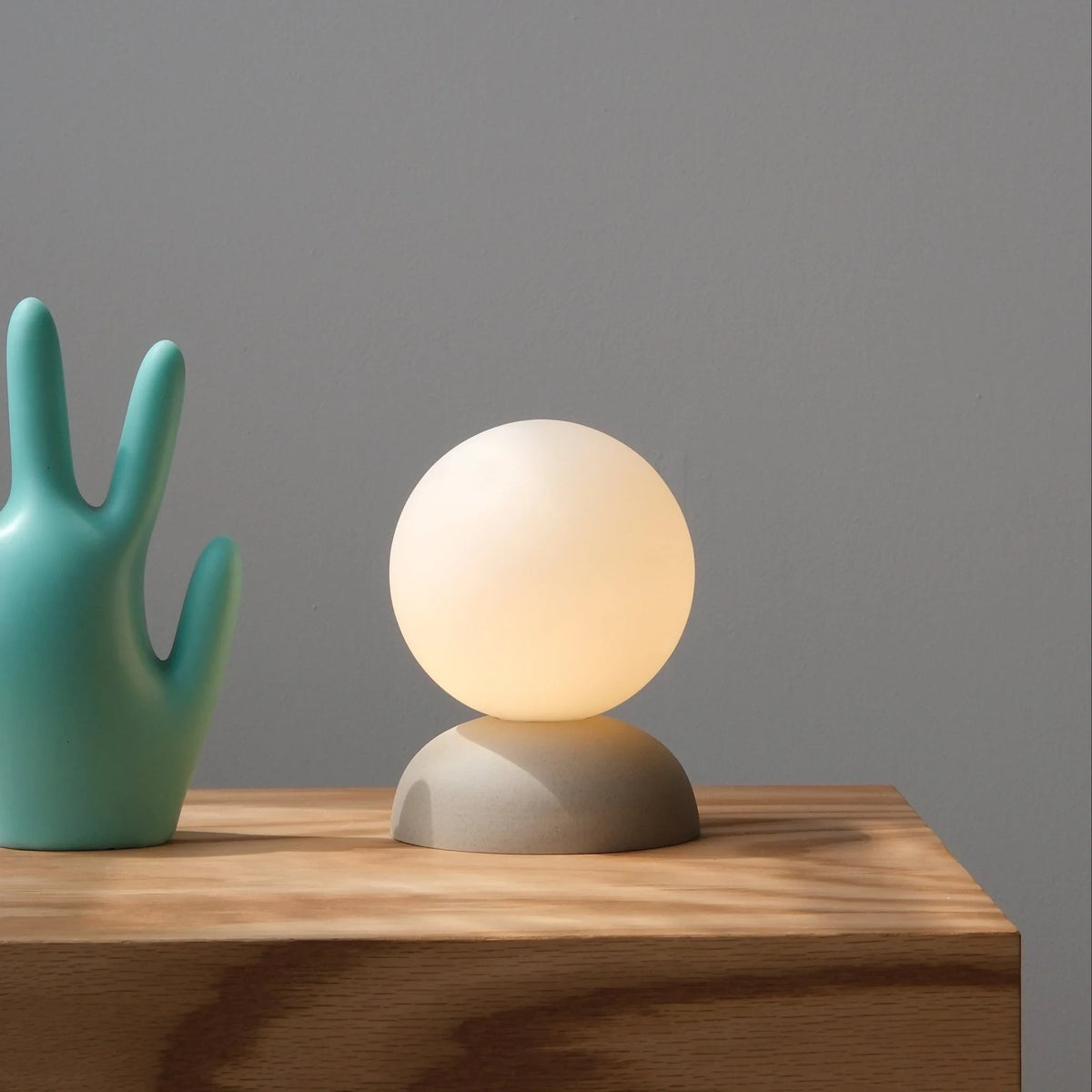 Glazed stoneware globe table lamp, in dune, lit