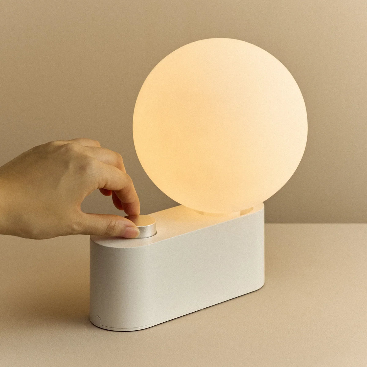 Globe table lamp or wall light, chalk, a hand adjusting the dial