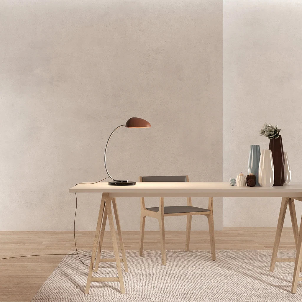Gooseneck table lamp with marble base, on a desk, with a terracotta shade