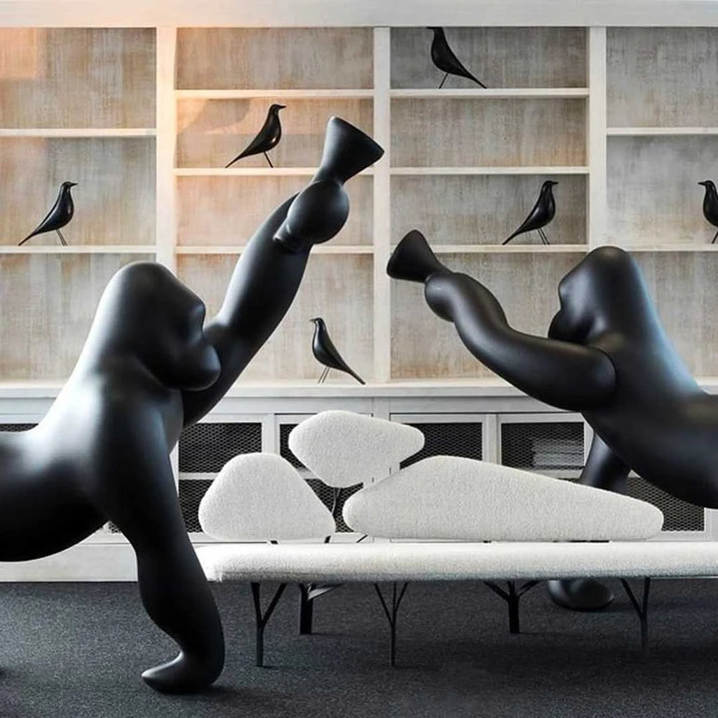 Gorilla floor lamp with an adjustable arm, in black in a living room with shelves