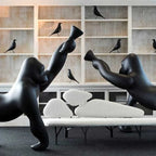Gorilla floor lamp with an adjustable arm, in black in a living room with shelves