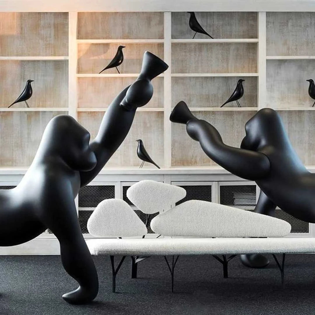 Gorilla floor lamp with an adjustable arm, in black in a living room with shelves