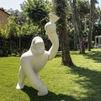 Gorilla floor lamp with an adjustable arm, in ivory on a lawn