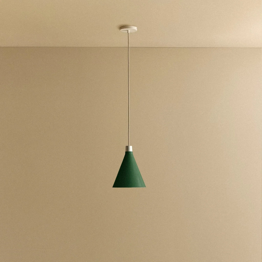 Dark Green cone pendant, small, with matte white dim-to-warm bulb, lit, against a plain wall