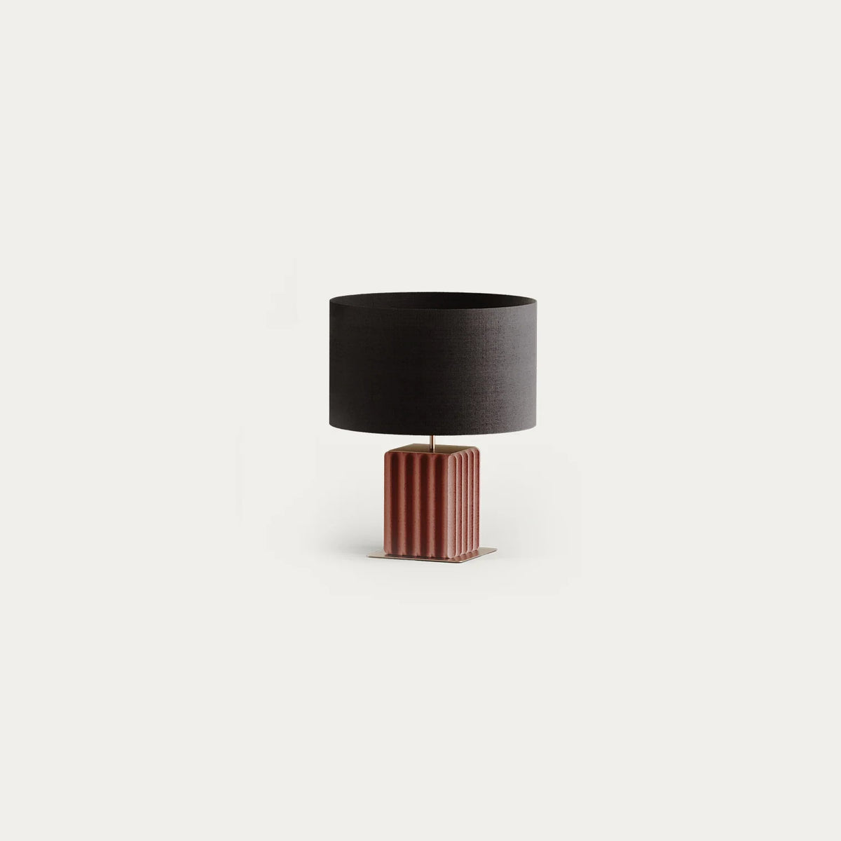 Grooved rectangular ceramic table lamp, in terracotta with a black drum shade, on a plain background