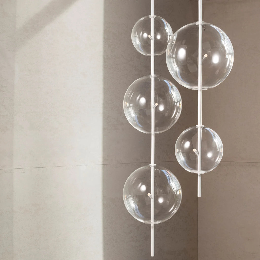 Hand-blown glass globe pendant on a steel stem, group of clear glass globes at different heights