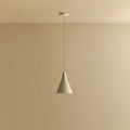 Small oyster white hand-spun steel cone pendant, against a plain wall