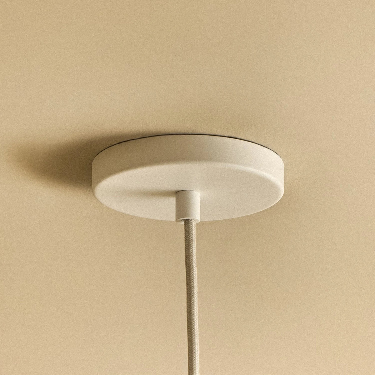 Small oyster white hand-spun steel cone pendant, close-up of the ceiling canopy