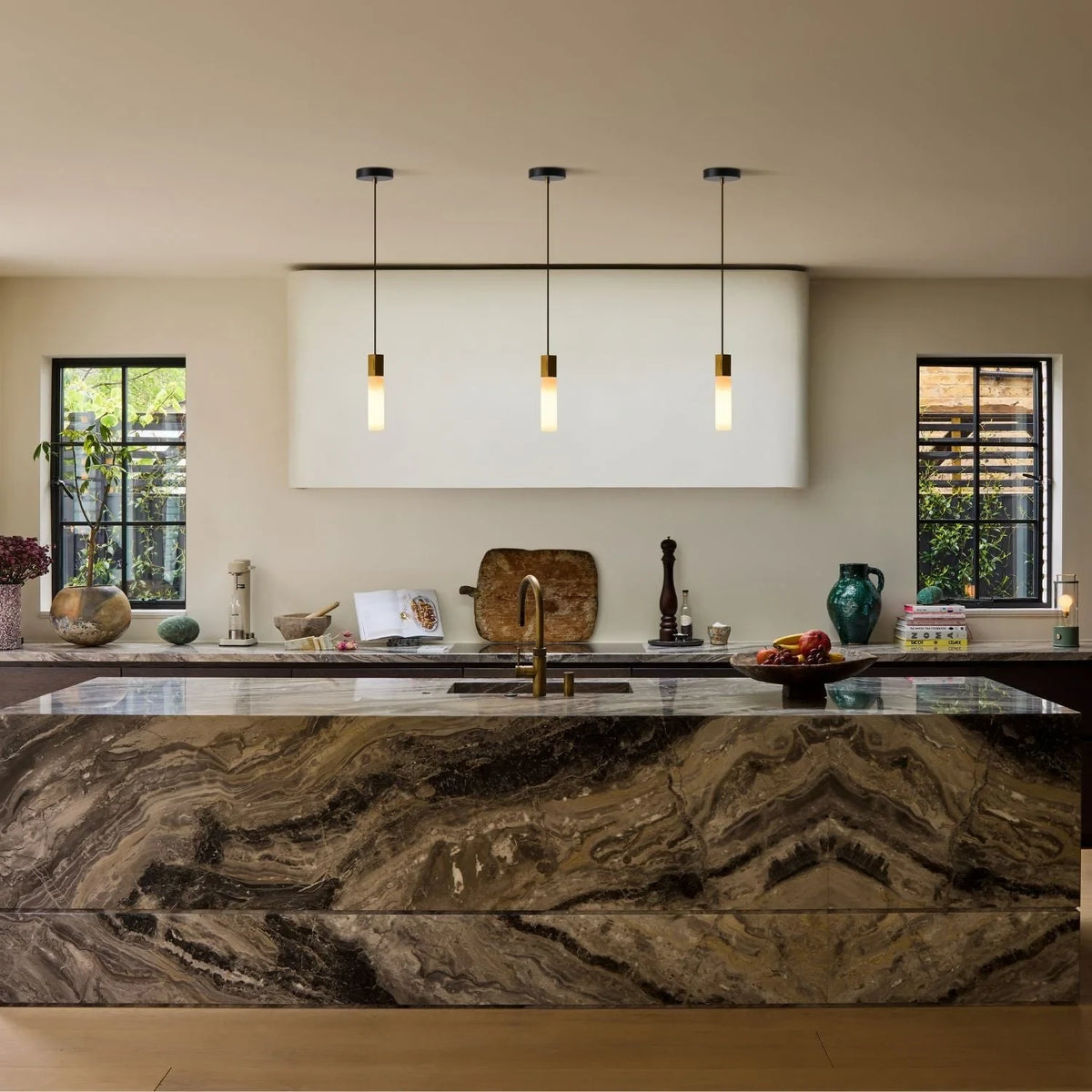 Hexagonal cast brass pendant with glass bulb, three above a stone kitchen island