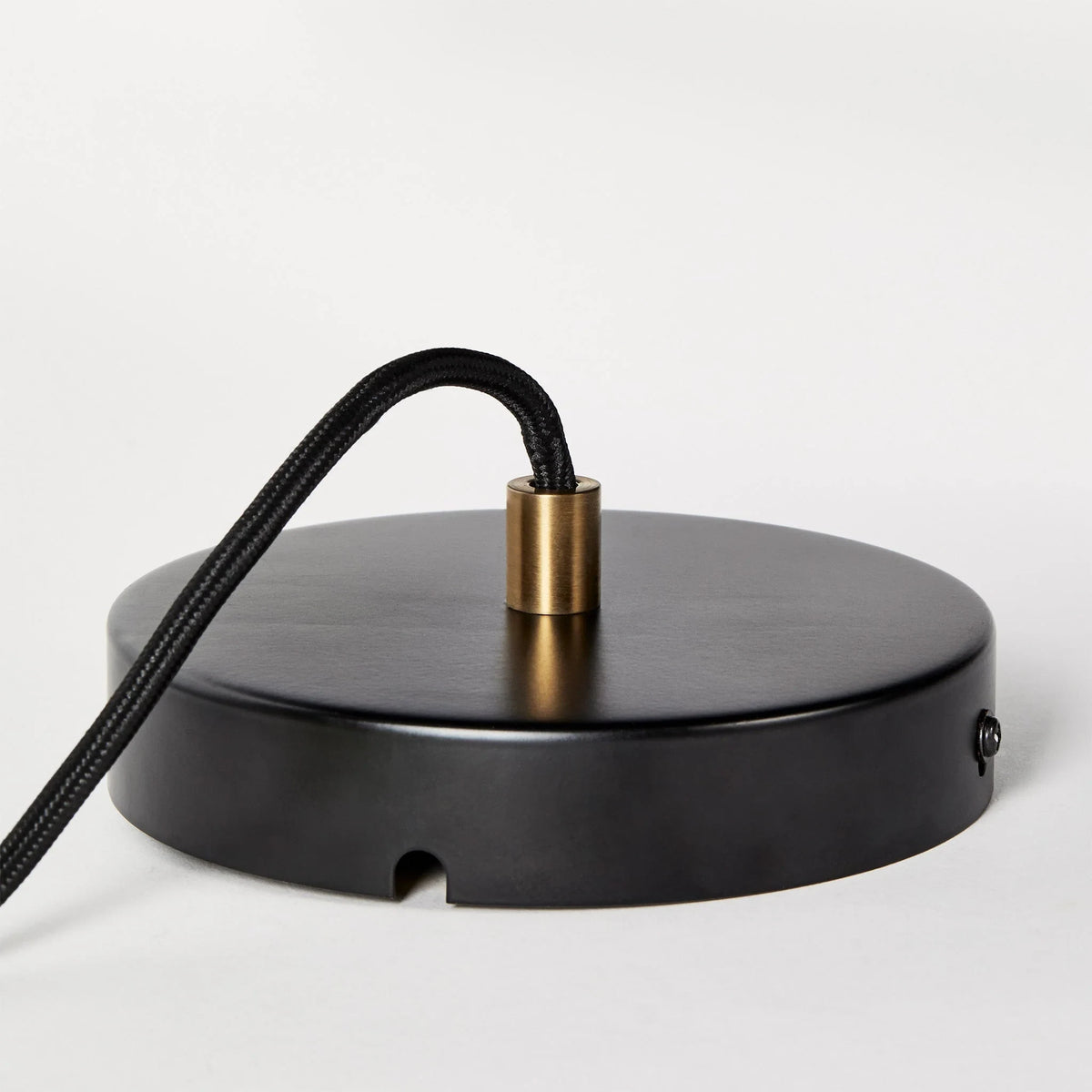 Hexagonal cast brass pendant with glass bulb, close-up of the black canopy