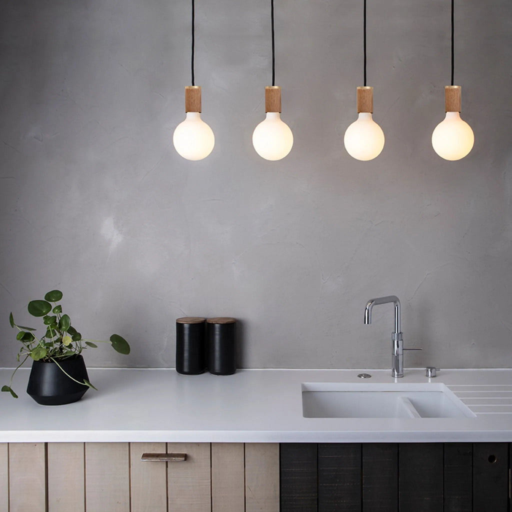 Large matte white globe pendant, oak, above a kitchen worktop