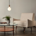 Large matte white globe pendant, oak, in a living room in walnut finish