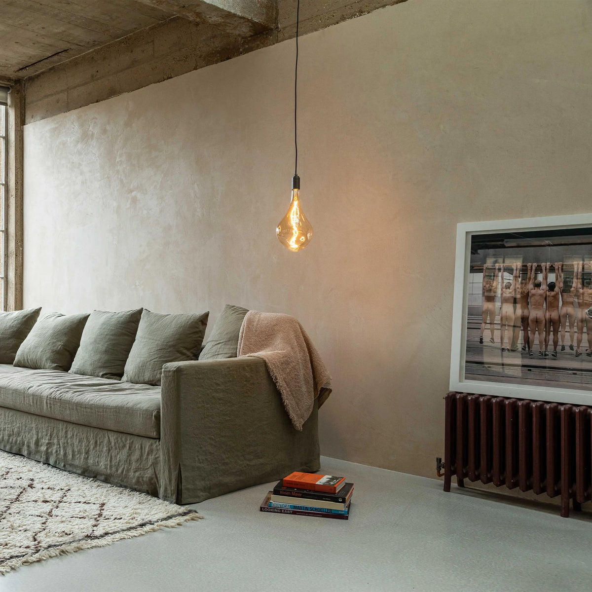 Set of three large teardrop tinted glass pendants, graphite, single pendant lit in a loft living room