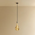 Large tinted sculptural bulb pendant, stainless steel, lit, against a plain wall