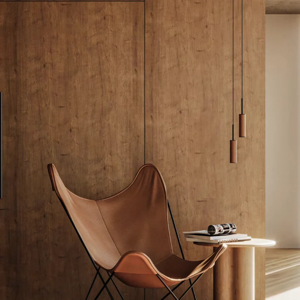 Leather-wrapped cylinder LED pendant, beside a leather lounge chair