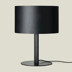 Leather drum shade table lamp, matte black base, with a black leather shade
