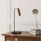 Leather-head spotlight desk lamp, marble base, with a brown leather head, on a wooden desk