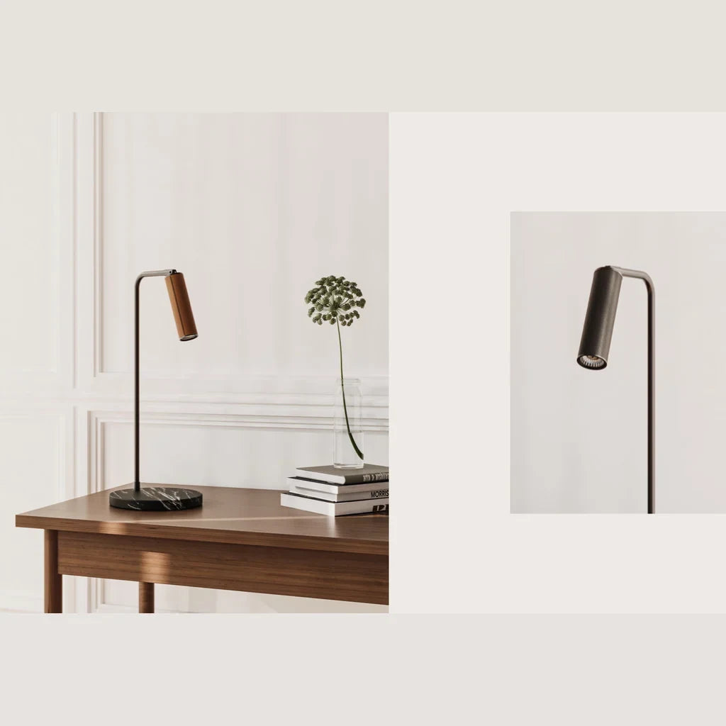 Leather-head spotlight desk lamp, marble base, with a brown leather head, beside books