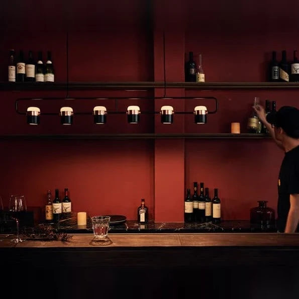 Linear frame LED pendant, in black above a bar counter