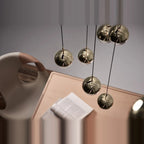 Linear glass globe pendant, five lights, globes in brass above a desk
