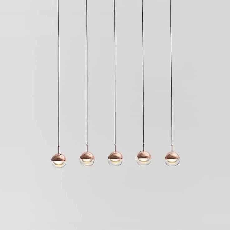 Linear glass globe pendant, five lights, in copper, in a row